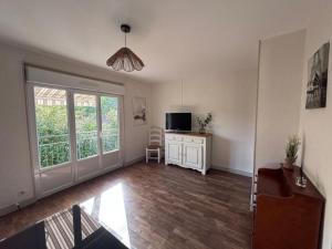 a living room with a large window and a television at la maisonnette in Nogent-le-Rotrou