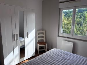 a bedroom with a dresser and a bed and a window at la maisonnette in Nogent-le-Rotrou