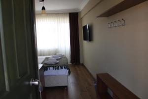 a room with a bed and a window and a table at cunda panorama otel in Ayvalık