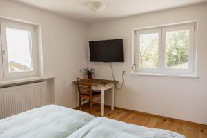 a bedroom with a bed and a desk with a tv at Haus Hermann in Schruns