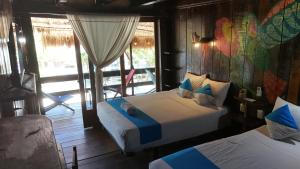 a bedroom with two beds and a balcony at Eco Cabañas Bluekay in Mahahual +246 photos