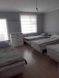 a bedroom with three beds and a window at Guest House South Wind in Pokrovka