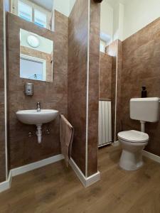 a bathroom with a sink and a toilet and a window at Zwinger Apartman in Sopron +13 photos