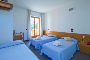 カスティオーネ・デッラ・プレゾラーナにあるHotel Cristallinoのベッド2台と窓が備わるホテルルームです。