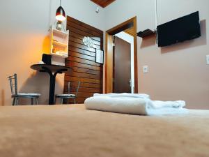 a bedroom with a bed with a tv on the wall at Pousada Estrela Do Luar in Urubici