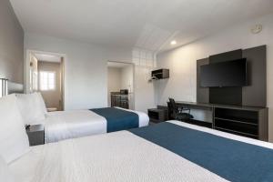 a hotel room with two beds and a flat screen tv at Studio 6 Rosemead, CA in Rosemead
