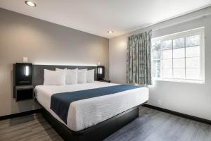 a bedroom with a large bed and a window at Studio 6 Rosemead, CA in Rosemead