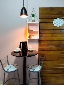 a table with two chairs and a coffee maker on it at Pousada Estrela Do Luar in Urubici