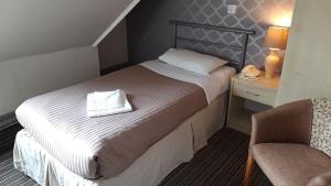 a hotel room with a bed and a chair at The Durley Chine Hotel in Bournemouth