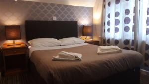 a bedroom with a bed with two towels on it at The Durley Chine Hotel in Bournemouth