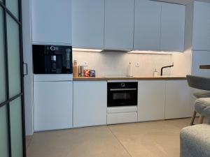 a kitchen with white cabinets and a microwave at Beach House Rodine - free parking & bikes in Scheveningen