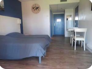 a bedroom with a bed and a table and a desk at Studio village 9 in Arles