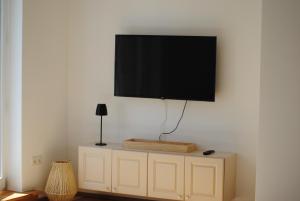 a flat screen tv on top of a white cabinet at MainApartment 1A in Margetshöchheim