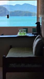 a bed in a room with a large window at Bem Me Quer - Hospedagem in Trindade