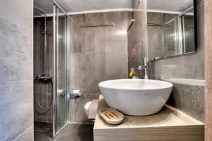 a bathroom with a large white sink and a shower at By Captains Studio in Ierapetra +29 photos