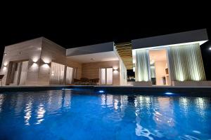 a large swimming pool in a hotel at night at Villa Stone in Smoković