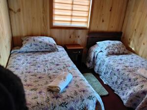 a room with two beds and a window in it at Cabañas almendra in Quellón