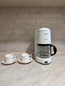 a coffee maker and two coffee cups on a counter at Erebuni in Yerevan
