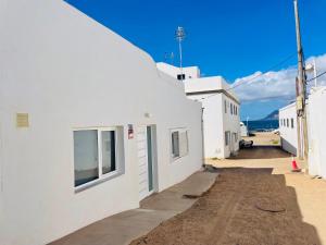 a street with white buildings and a blue sky at Casa Señora Reyes in Famara