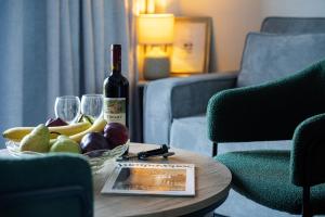 a bottle of wine and a bowl of fruit on a table at By Captains Studio in Ierapetra