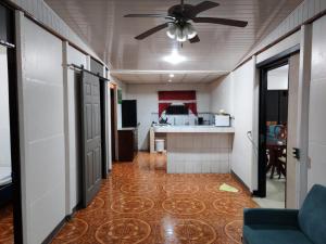 a living room with a ceiling fan and a kitchen at Casa Congo in Golfito