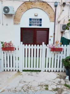 a white fence with two potted plants in front of a door at House Under Arch in Palermo