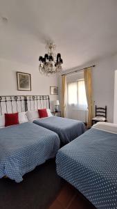 ein Schlafzimmer mit zwei Betten und einem Kronleuchter in der Unterkunft Hotel Los Caspios in Colunga