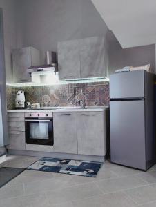 a kitchen with a white refrigerator and a sink at House Under Arch in Palermo