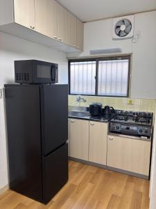 a kitchen with a black refrigerator and a stove at Seaside accommodation - Vacation STAY 22044 in Horiechō