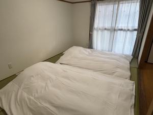 an unmade bed in a room with a window at Seaside accommodation - Vacation STAY 22044 in Horiechō