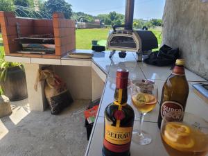 two bottles of wine and glasses on a table with a grill at Gite espumante in Mamarrosa