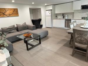 a living room with a couch and a table and a kitchen at 2BDRM-Kitchenette-BBQ-Smart TV-4-5Guest in West Vancouver