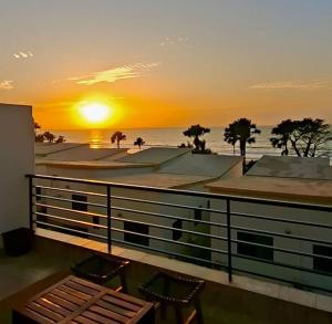 a sunset from the balcony of a building at Sea view beach apartment in Bijilo