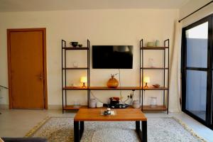a living room with a table and a tv at Sea view beach apartment in Bijilo