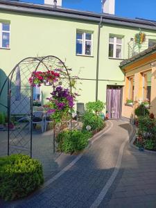 a house with a garden with flowers and a gate at Kamienica Senator in Skierniewice