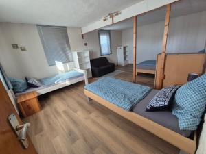 a bedroom with two bunk beds and a couch at Monteurhaus Dautphe in Friedensdorf