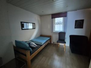 a small bedroom with a bed and a chair at Monteurhaus Dautphe in Friedensdorf +23 photos