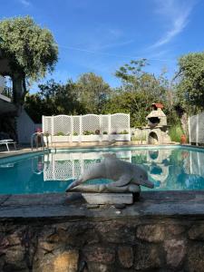 a dolphin statue sitting next to a swimming pool at Villa Marlene in Astris