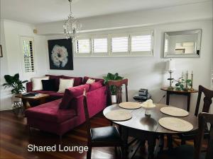 a living room with a red couch and a table at Nicole Guest House - Private Room & Bathroom - 6kms from City in Brisbane