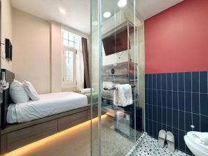a bathroom with a bed and a glass shower at A Hotel Chinatown in Singapore +55 photos