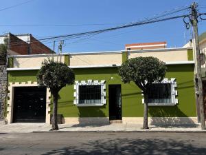 a green building with two trees in front of it at Hotel casa el Palomar - 3 in San Baltasar