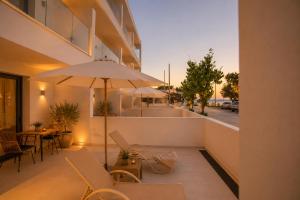 a balcony with a table and an umbrella on a building at Kastri Beach Suites in Faliraki