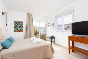 a bedroom with a bed and a flat screen tv at Eden Rentals Oasis Boho 1 in Las Galletas
