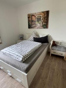 a bed in a bedroom with a painting on the wall at Fewo Am Poetenteich in Jänkendorf