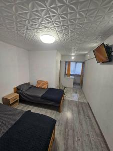 a bedroom with two beds and a tv on the ceiling at BOMBA Apart in Târgu Secuiesc