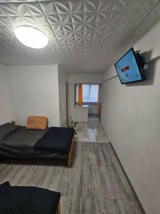 a bedroom with a bed and a flat screen tv at BOMBA Apart in Târgu Secuiesc