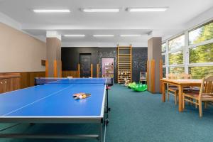 a room with a ping pong table in a classroom at Horský Hotel Jelínek in Bedřichov