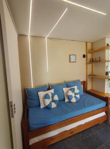 a bed in a small room with blue pillows at Best location of the development, ground floor seafront in Porto De Galinhas +94 photos