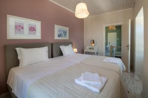 a bedroom with a large white bed with towels on it at Villa Maritsa, Magazia in Gaios