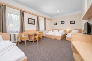 a hotel room with two beds and a table at Horský Hotel Jelínek in Bedřichov +39 photos